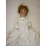 A Cuno & Otto Dressel bisque head character doll with blue glass sleeping eyes, open mouth and