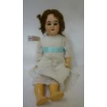An Armand Marseille bisque head doll with brown glass sleeping eyes, open mouth and teeth, brown