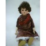 An S.F.B.J. bisque head doll with fixed brown glass eyes, open mouth and teeth, later brown mohair