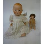 An Armand Marseille bisque head baby doll with blue glass sleeping eyes, open mouth and teeth,