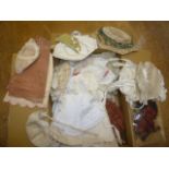 A quantity of early 20th century dolls' clothing including dresses, bonnets, hats, in cotton, lace