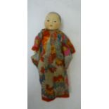 An Armand Marseille bisque head oriental baby doll with brown glass sleeping eyes, closed mouth,