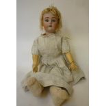 A Kammer & Reinhardt bisque head doll with blue glass sleeping eyes, open mouth and teeth, pierced