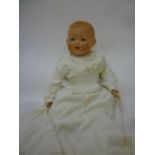 An Armand Marseille bisque head baby doll with blue glass sleeping eyes, open mouth and teeth,