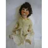 An Ernst Heubach bisque head character doll with blue glass sleeping eyes, open mouth and teeth with