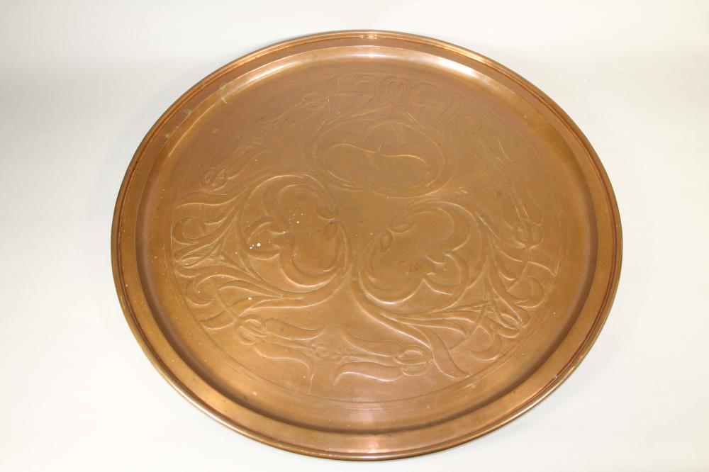 A KESWICK SCHOOL ARTS AND CRAFTS COPPER PLAQUE of plain circular form, chased with stylised