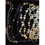 Four strings of beads including cultured pearl, coral, lapis lazuli some with 9 carat fittings.