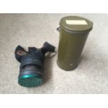A WWII civilian gas mask in original metal container. Dated 1940.