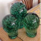 Trio of green glass Castleford door stops.