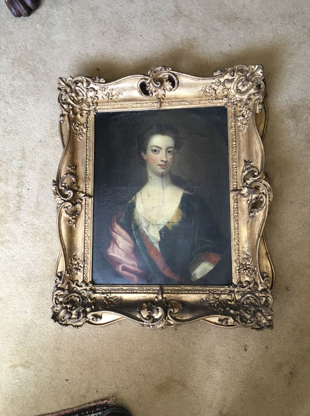 An 18thC portrait of a lady, oil on canvas in original swept gilt frame (bad tear and repair (