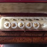 Mother of pearl and fox mask buttons in fitted case, one button missing.