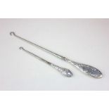 A George V embossed silver handled button hook together with a larger silver handled button hook (