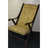 A Victorian x-framed armchair in gold damask upholstery