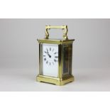 A brass and bevelled glass cased carriage clock with white enamel dial and Roman numerals, maker