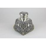 A silver plate mounted travelling glass bottle with embossed cherub, floral and scroll motifs and