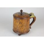 A fruitwood tankard with brass hinge on three ball feet 18cm high