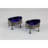 A pair of George III silver salts with blue glass liners, beaded edges and pierced decoration on