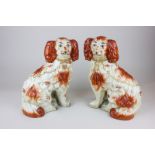 A very near pair of Staffordshire seated spaniels, decorated in rust colouring, 27cm high