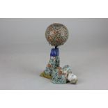 A Chinese porcelain pin cushion, in the form of an acrobat, balancing a ball on his feet, marks to