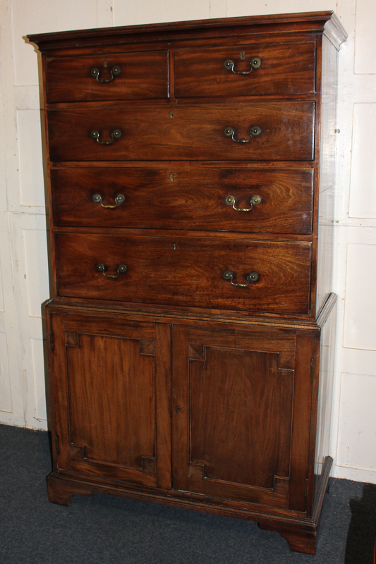 A George III mahogany chest on cabinet, the top section with two short over three long drawers,