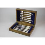 A set of six mother of pearl handled silver plated dessert knives and forks in fitted oak case