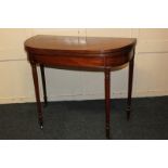 A 19th century mahogany card table with bowfront fold-over top, (no longer resting flat) with