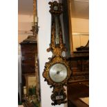 A 19th century papier mache wall barometer and thermometer, with scroll border and allover gilt
