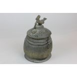 An Asanti silverised pot with lid, the finial modelled as a bird and a serpent (af) 17.5cm high