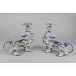 A pair of Italian majolica candlesticks modelled as a mythical beast facing behind with