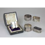 An Art Nouveau cased silver and enamel napkin ring monogrammed, marks worn, together with four