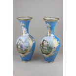A pair of Victorian glass vases decorated with scenes of youthful lovers with gilt embellishment