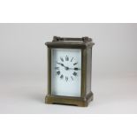 A brass and bevelled glass cased carriage clock with Roman numerals, the movement marked, made in