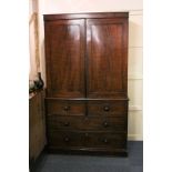 A George III mahogany press cupboard with panelled cupboards enclosing hanging rail, above two short