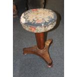 A tapestry topped circular piano stool on mahogany base, the octagonal support above three feet (