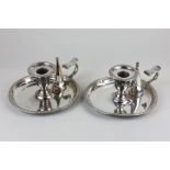 A pair of 19th century silver plated chamber sticks with gadroon border, with insignia to handle,