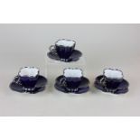 A set of four Art Nouveau style porcelain coffee cups and saucers with cobalt blue ground and