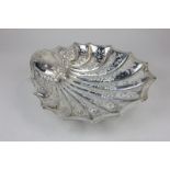 An Edwardian silver shell shaped dish with embossed floral detail and cutout scroll design, maker