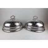 A pair of silver plated domed shaped oval covers, with engraved decoration and gadroon border 35cm