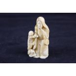 A late 19th, early 20th century Chinese ivory figure of a woman and a crouching man wearing a