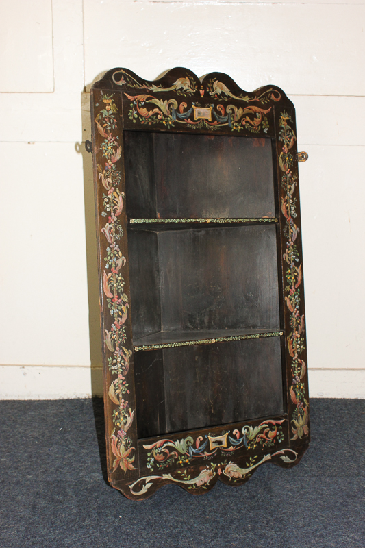 A painted hanging corner unit, with three shelves, decorated in colours with scrolling foliage, 80cm