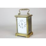 A French brass and bevelled glass cased carriage clock the white enamel face with Roman numerals,