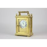 An ormolu and bevelled glass cased carriage clock with Tiffany movement, scroll decoration and egg