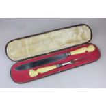 A Victorian carving set with ivory handles carved as Napoleon III and his wife Eugenie, the blade