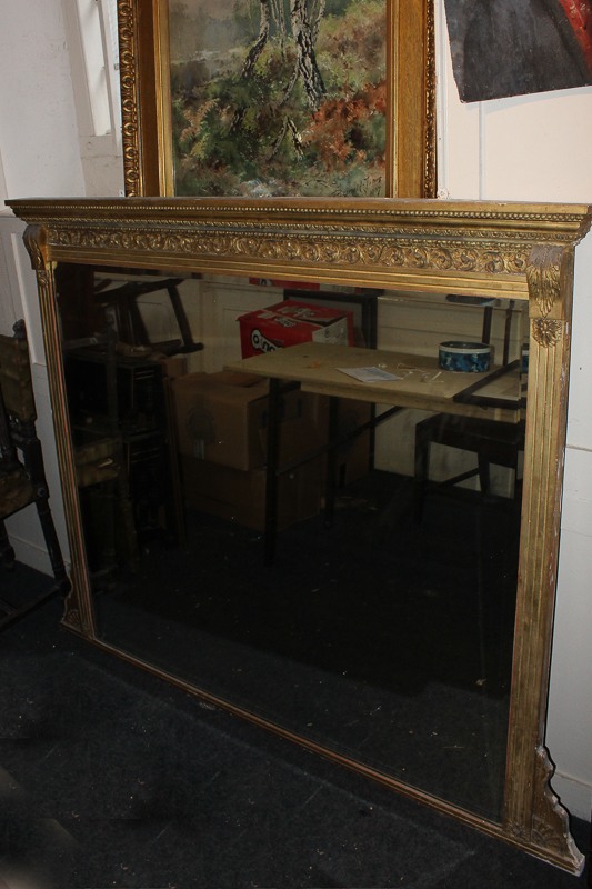 A carved gilt wood and gesso rectangular wall mirror, with scroll frieze and fluted uprights,