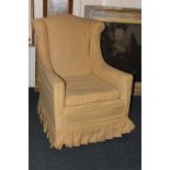 An upholstered wingback armchair, with gold floral lattice fabric cover on square tapered feet and