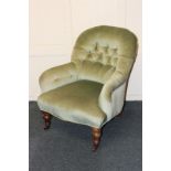 A Victorian green button upholstered armchair on turned legs and castors