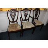 Three Edwardian shield back dining chairs, including a carver, with inlaid panel, drop-in