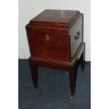A George III mahogany decanter box, square form with raised top, on square tapered legs with carry