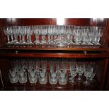 A large collection of cut glass drinking glasses including flutes, tumblers, wine and liqueur