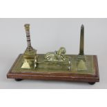 An early 20th century Egyptian brass souvenir desk stand decorated with a sphinx, inkwell, an